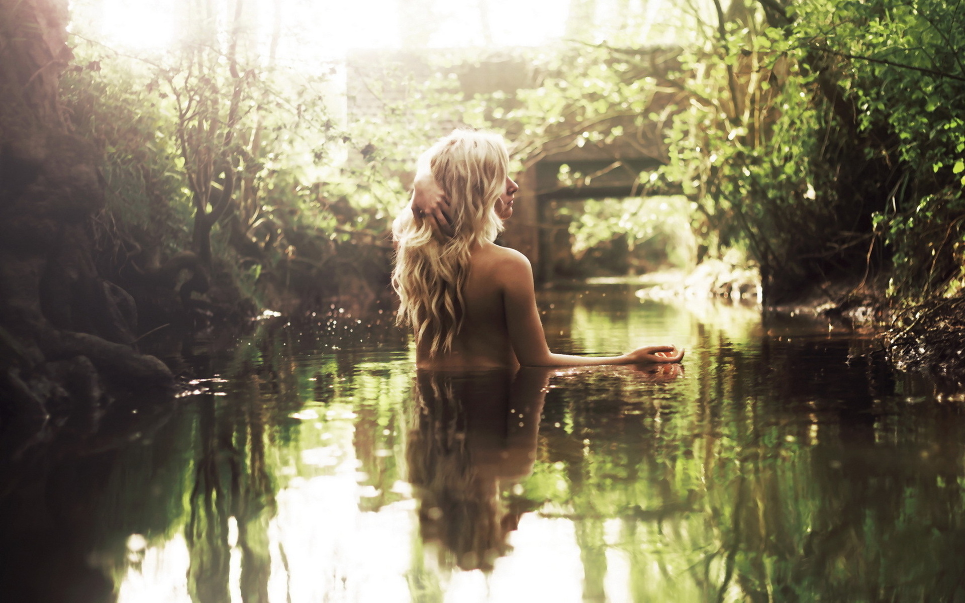 Худенькая блондинка на берегу озера показывает прелести