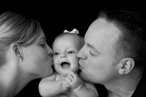 Parents kiss Baby Girl