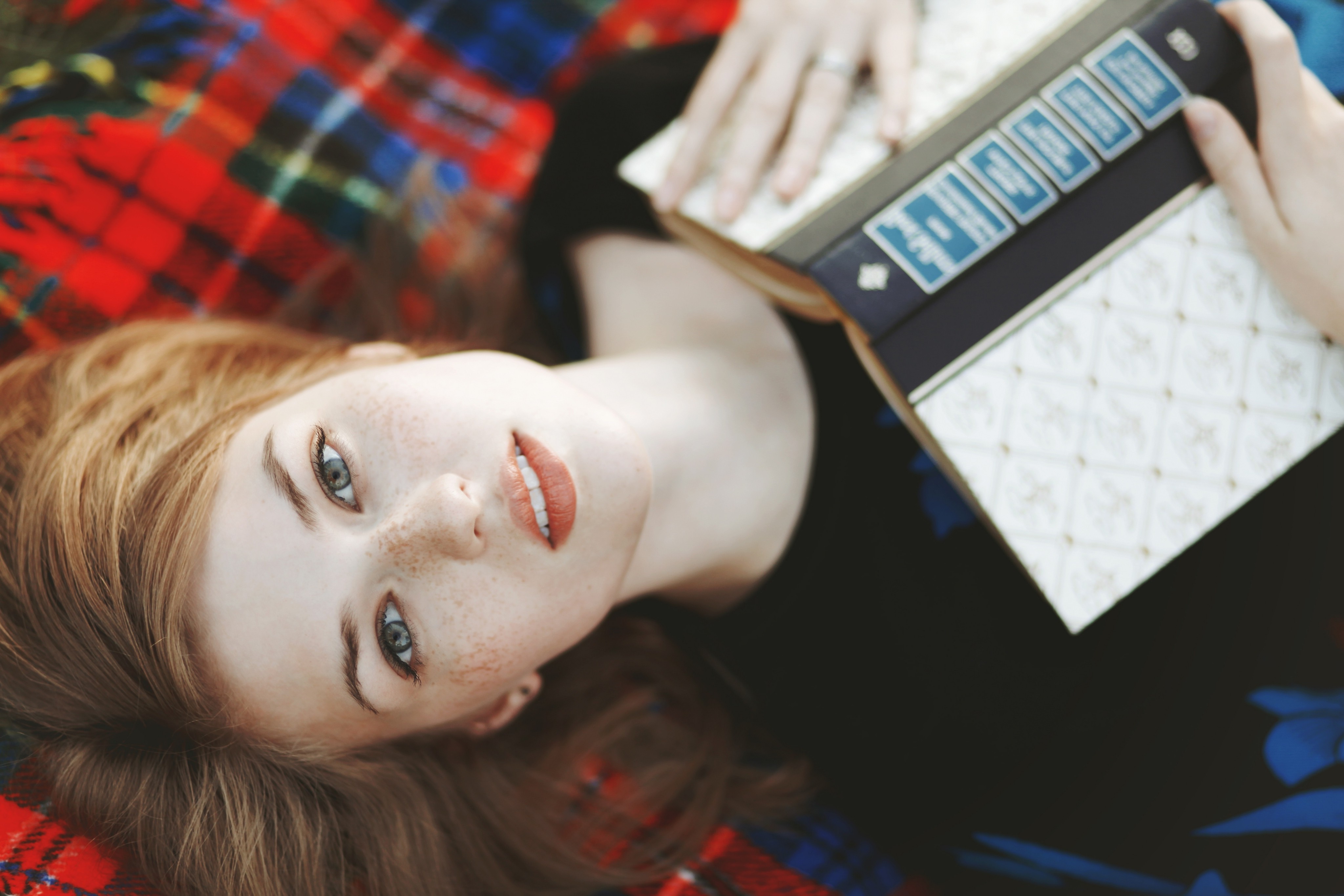 women, Redhead, Freckles, Looking At Viewer, Lying On Back, Books, Tartan Wallpaper