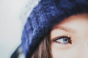 closeup women woolly hat blue eyes