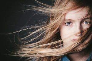 women hair in face blonde blue eyes portrait