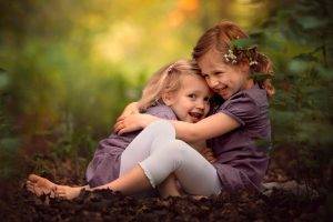 little girl children hugging smiling depth of field