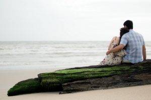 beach rock sitting couple hugging