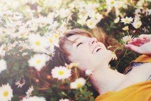 laughing lying on back women outdoors closed eyes white flowers daisies sunlight