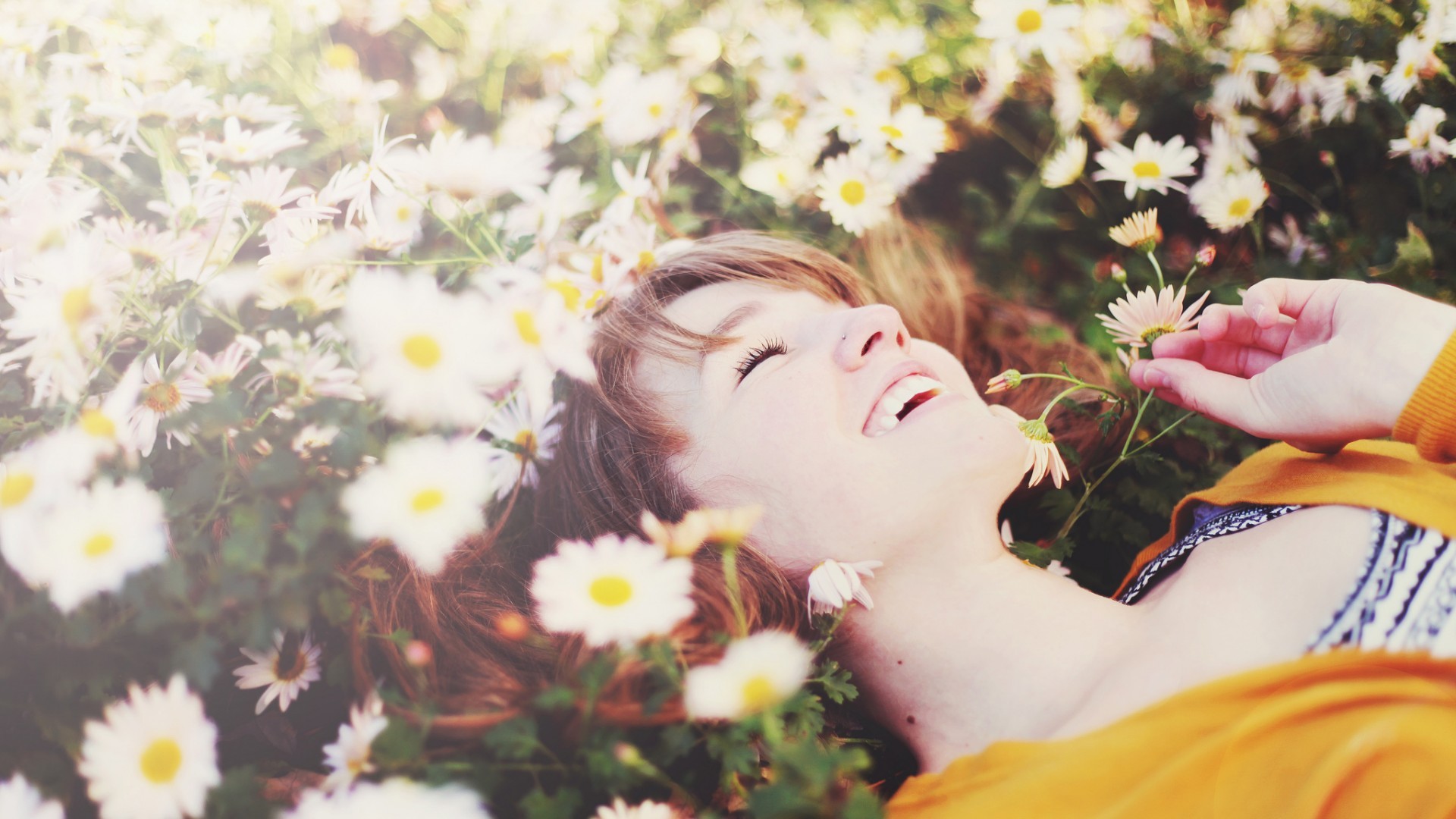laughing lying on back women outdoors closed eyes white flowers daisies sunlight Wallpaper