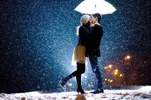 couple kissing snow umbrella bokeh