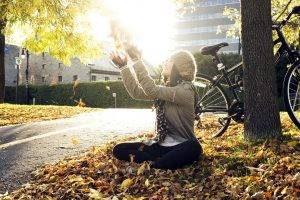 fall trees bicycle road sitting sunlight women outdoors