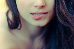 women model long hair biting lip face brunette depth of field