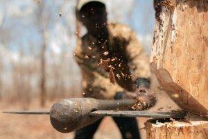 men black people trees axes chopping depth of field splinters wood