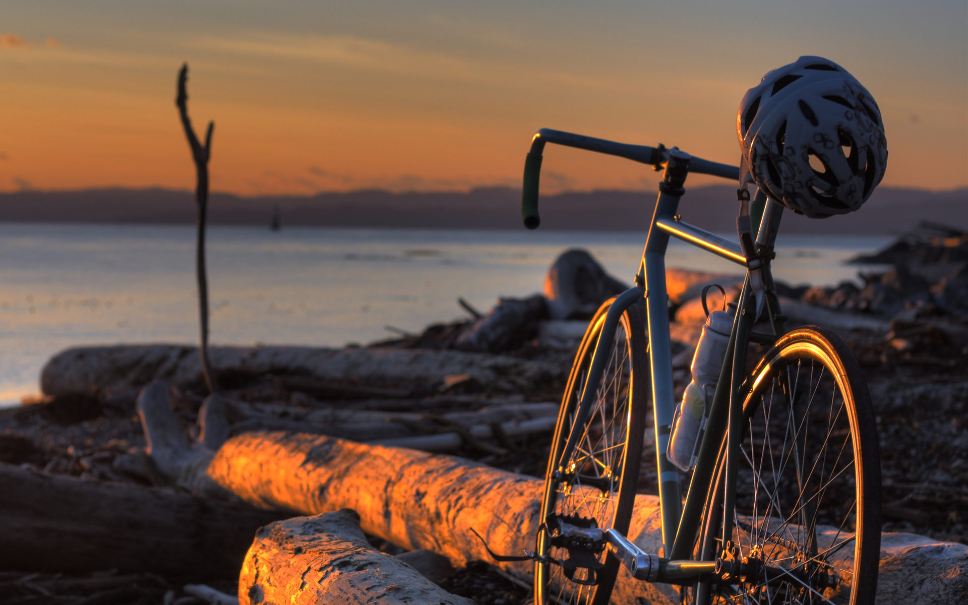 vehicles, Bicycle, Bike, Wheels, Frame, Mech, Spokes, Helmet, Hat, Sports, Landscapes, Beaches, Driftwood, Wood, Lakes, Water, Sunset, Sunrise, Sky, Clouds Wallpaper